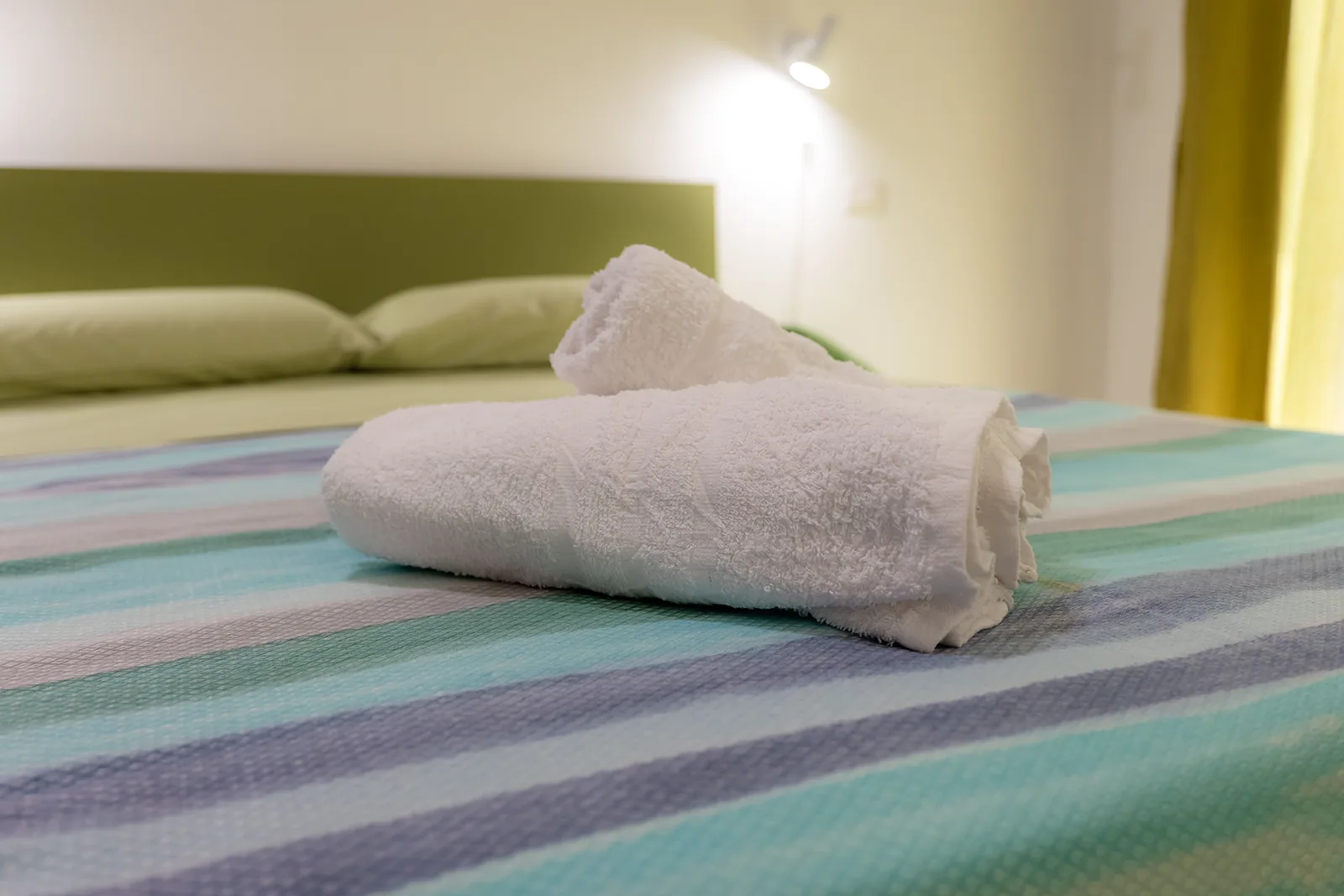 Primo piano di asciugamani arrotolati sul letto della Dimora dei Ricci
