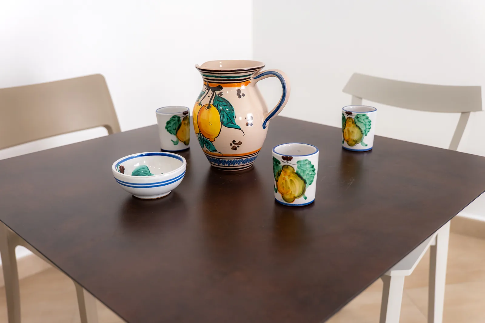 Brocca e bicchieri in ceramica sul tavolo della cucina comune